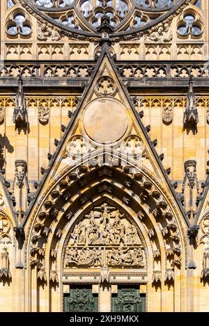 Aus nächster Nähe sehen Sie die Veitskathedrale mit kunstvollen Steinschnitzereien, Statuen und einem großen Rosenfenster im goldenen Sonnenlicht. Stockfoto