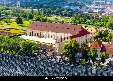 Aus der Vogelperspektive des historischen Prager Schlosses Reithalle mit seinem roten Dach, aufgenommen an einem sonnigen Sommertag, umgeben von üppigen grünen Gärten. Prag, Tschechien Stockfoto