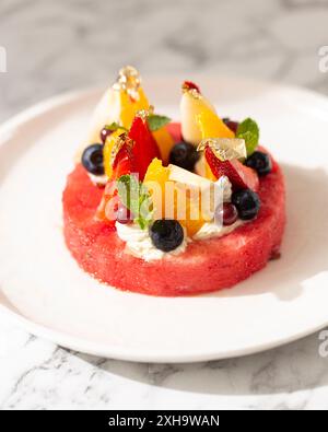 Nahaufnahme eines exquisiten Obstdesserts mit frischen Beeren und luxuriösen Goldflocken. Stockfoto