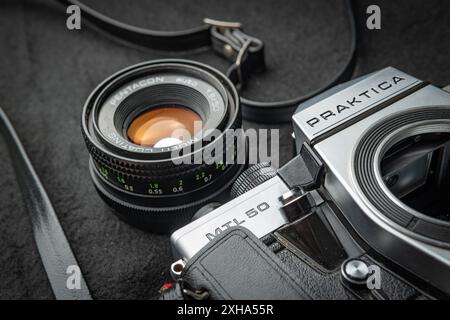 Walbrzych, polen - 12. Juli 2024: Deutsche Praktica MTL 50 Kamera mit Objektiv auf schwarzer Oberfläche Stockfoto