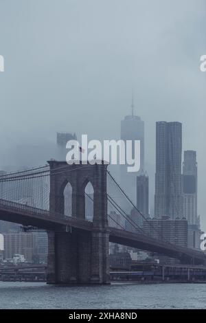 Brooklyn Bridge und One World Trade Center an einem grauen, regnerischen Stormy Day in New York City Stockfoto