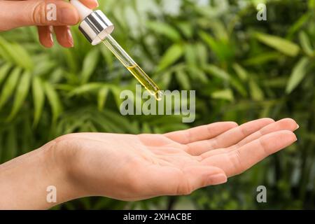 Frau tropft im Freien ätherisches Öl aus der Pipette, Nahaufnahme Stockfoto