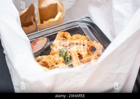 Ein Blick in eine Plastiktüte, in der Behälter mit zubereiteten Speisen zum Mitnehmen in einem Restaurant untergebracht sind. Stockfoto