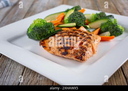 Blick auf einen Teller mit gegrilltem Lachs und gedämpftem Gemüse. Stockfoto