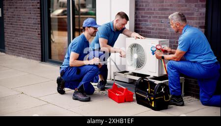 Erfahrener HLK-Techniker, der das Team bei der Installation von gewerblichen Klimaanlagen leitet: Qualitätssicherung für den Wartungsservice für Gebäude mit Steuergeräten Stockfoto