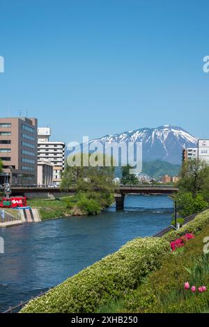 Genießen Sie die ruhige Schönheit von Morioka von der Kaiun-Brücke aus: Ein atemberaubender Blick auf den Mount Iwate mit seinem schneebedeckten Gipfel, dem klaren blauen Himmel und den Bergen Stockfoto