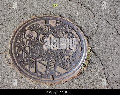 Ein Mann-Loch-Cover im Samurai-Stil in der Nähe der Samurai Street, Kakunodate, Akikta, Japan Stockfoto