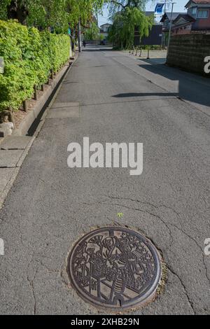 Ein Mann-Loch-Cover im Samurai-Stil in der Nähe der Samurai Street, Kakunodate, Akikta, Japan Stockfoto