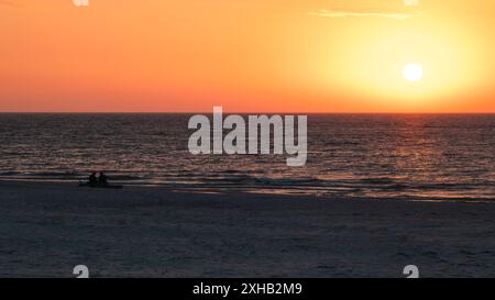 Wunderschöner Sonnenuntergang über der Ostsee. Silhouetten von zwei Personen am Strand, die den Sonnenuntergang beobachten. Slajszewo, Polen Stockfoto