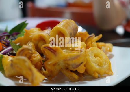 Frittierter Tintenfisch mit süßer Sauce auf weißem Teller. Südostasiatische Küche Stockfoto