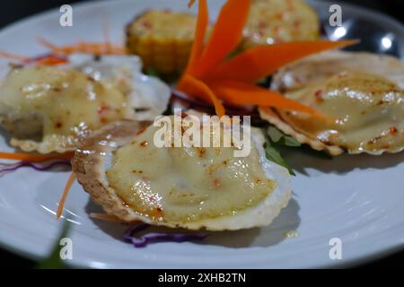 Gegrillte Jakobsmuscheln auf weißem Teller im Restaurant, Nahaufnahme Stockfoto