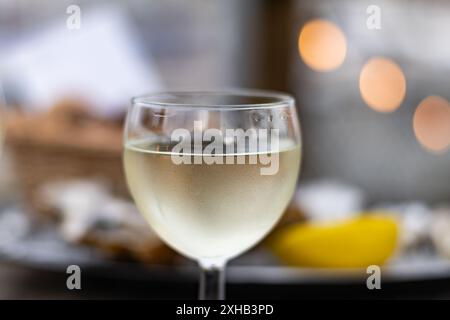 Verkostung von Bordeaux-Weißwein, rechtes Ufer der Gironde-Mündung, Frankreich. Gläser weißen, süßen französischen Weines, serviert im Außenrestaurant, Austern Farm Stockfoto