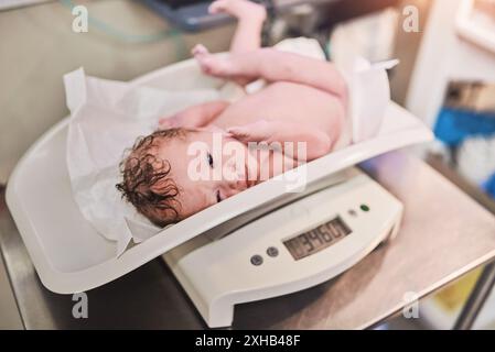 Neugeborene, Kind und Baby auf Waage im Krankenhaus für Gewichtsmessung, Gesundheit und Wellness. Säugling, Digital und Kind auf Balance in der Klinik in der Medizin Stockfoto