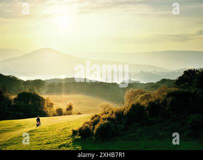 Bantry Bay Golf Club Platz, County Cork Sommerabend. Mann mit Golf-Caddy. Bantry Bay und Caha Berge in der Ferne. Irland Stockfoto
