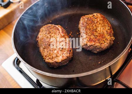 Rinderfilet-Steaks mit Gewürzen in heißer Pfanne , England, UK Stockfoto