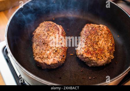 Rinderfilet-Steaks mit Gewürzen in heißer Pfanne , England, UK Stockfoto