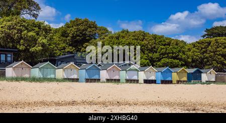 Eine Reihe farbenfroher Strandhütten in Mudeford in Dorset, England, Großbritannien Stockfoto