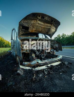 Ein ausgebranntes Auto auf der Autobahn. Es ist ein totaler Verlust, unbrauchbar, ein Wrack Stockfoto