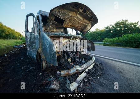 Ein ausgebranntes Auto auf der Autobahn. Es ist ein totaler Verlust, unbrauchbar, ein Wrack Stockfoto