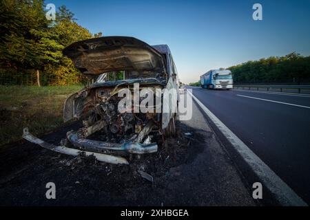 Ein ausgebranntes Auto auf der Autobahn. Es ist ein totaler Verlust, unbrauchbar, ein Wrack Stockfoto