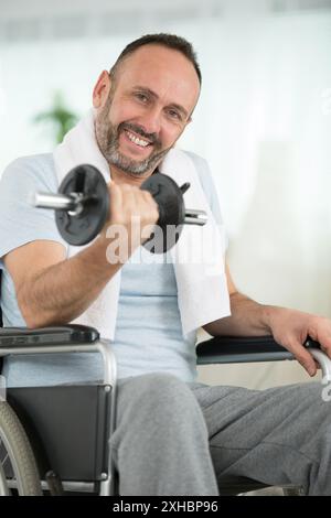 Positiver Mann im Rollstuhl versucht, besser zu werden Stockfoto