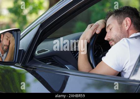 Junger Mann, der in seinem Auto schläft Stockfoto