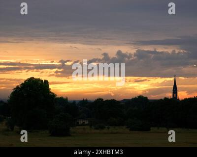 Ein romantischer Sonnenuntergang spiegelt sich in der Elbe. Im Hintergrund erscheint die Dresdner Skyline mit der Dreikönigskirche als Silhouette. Stockfoto