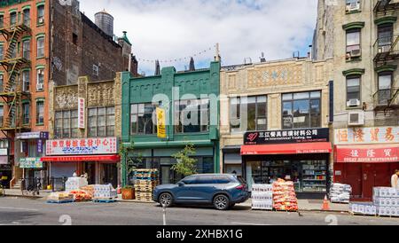 NYC Chinatown: Drei zweistöckige Geschäftsgebäude mit interessanten Ziegelsteinmauern in den Brüstungen über den Ladenfronten. Stockfoto