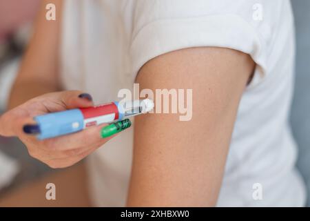 Frau spritzt sich zu Hause das Medikament Ozempic Anti-Diabetes Pen in ihren Arm. Gewichtsverlust und Blutzuckerabfall, Konzeptidee. Einspritzdüsen-DO Stockfoto