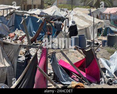 Khan Younis, Gaza. Juli 2024. Die Palästinenser betrachten die Trümmer zerstörter Zelte und bauen Wohnbauten nach einem israelischen Militärschlag auf das Lager al-Mawasi für Binnenvertriebene (IDP) in der Nähe der Stadt Khan Yunis im südlichen Gazastreifen am Samstag, dem 13. Juli 2024, bei dem 71 Menschen getötet wurden. Al-Mawasi wurde von Israel zur Sicherheitszone erklärt. Foto: Saber Arar/UPI Credit: UPI/Alamy Live News Stockfoto