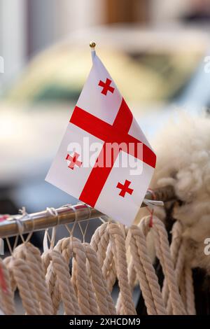 Kleine georgianische Flagge mit roten Kreuzen auf weiß, verkauft in einem Souvenirladen in Batumi, Adjara, Georgia. Stockfoto