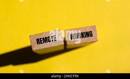 Meldung über Fernbetrieb auf Holzblöcken mit gelbem Hintergrund. Konzeptionelles Symbol für Remote Working. Kopierbereich. Stockfoto