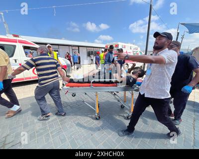 Khan Younis, Gaza. Juli 2024. Verwundete Palästinenser, darunter Kinder und Frauen, werden nach dem israelischen Angriff am Samstag, dem 13. Juli 2024, in Khan Yunis, Gaza, ins Kuwait Field Hospital gebracht, bei dem 71 Menschen getötet wurden. Al-Mawasi wurde von Israel zur Sicherheitszone erklärt, als es seine militärische Offensive in anderen Teilen des Gazastreifens fortsetzt. Foto: Saber Arar/UPI Credit: UPI/Alamy Live News Stockfoto