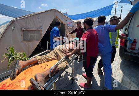 Khan Younis, Gaza. Juli 2024. Verwundete Palästinenser, darunter Kinder und Frauen, werden nach dem israelischen Angriff am Samstag, dem 13. Juli 2024, in Khan Yunis, Gaza, ins Kuwait Field Hospital gebracht, bei dem 71 Menschen getötet wurden. Al-Mawasi wurde von Israel zur Sicherheitszone erklärt, als es seine militärische Offensive in anderen Teilen des Gazastreifens fortsetzt. Foto: Saber Arar/UPI Credit: UPI/Alamy Live News Stockfoto