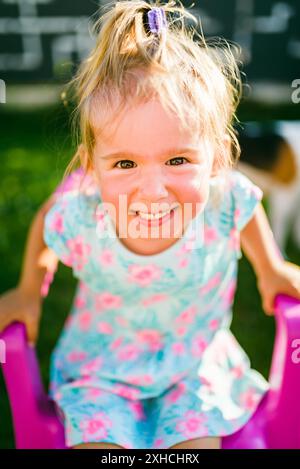 Wunderschönes Mädchen-Porträt, grüner Hof. 2-3-jähriges Kind in der Natur am sonnigen Sommertag Stockfoto