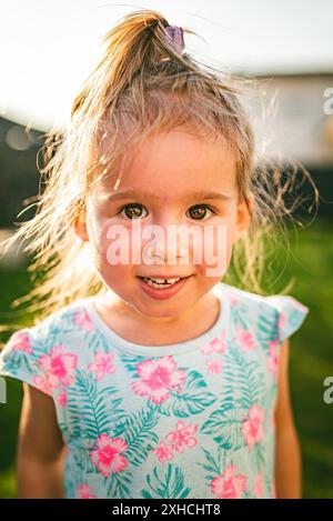 Wunderschönes Mädchen-Porträt, grüner Hof. 2-3-jähriges Kind in der Natur am sonnigen Sommertag Stockfoto