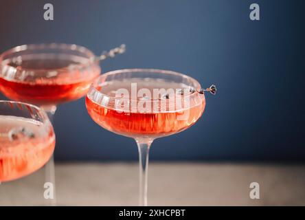 Gläser mit kaltem rosafarbenem Champagner und Lavendelblüten auf dem Tisch Stockfoto