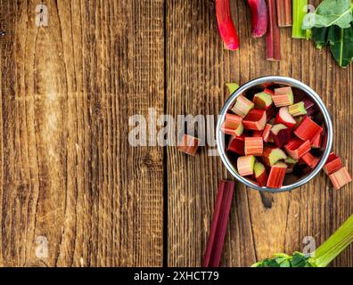 Gehackter Rhabarber auf einem alten Holztisch (Nahaufnahme, selektiver Fokus) Stockfoto