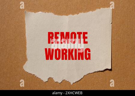 Nachricht für die Fernarbeit auf gerissenem Papier mit Papphintergrund geschrieben. Konzeptionelles Symbol für Remote Working. Kopierbereich. Stockfoto