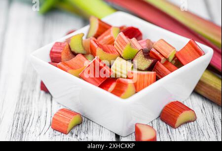 Gehackter Rhabarber auf einem alten Holztisch (Nahaufnahme, selektiver Fokus) Stockfoto