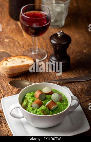 Cremige Erbsensuppe auf dunklem Holz Stockfoto