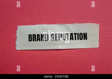 Markenbotschaft auf gerissenem Papier mit rotem Hintergrund. Konzeptionelles Markenimage. Kopierbereich. Stockfoto