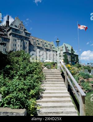 Treppen führen zur Manoir Richelieu Fassade mit landschaftlich gestaltetem Innenhof im Sommer, Charlevoix, Quebec, Kanada Stockfoto