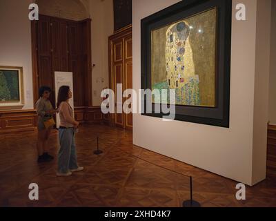 Wien, Österreich - 28. Juli 2023: Innenausstattungen im Schloss Belvedere. Barockpalast. Besucher in den Museumsräumen sehen das berühmte Leinwandbild Kiss von Gustav Klimt Stockfoto