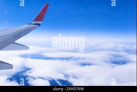 Flügel eines Flugzeugs während eines Fluges mit blauem Himmel über Wolken. Hintergrundbild. Kopierbereich Stockfoto