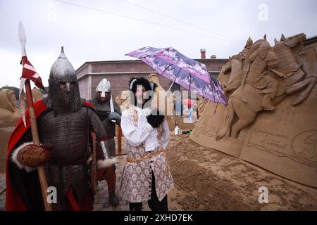 Animatoren, die während des jährlichen Sandskulpturenfestes im Alekseevsky Ravelin der Peter-und-Paul-Festung als Ritter gekleidet sind, in der Nähe von Sandskulpturen. Das diesjährige Thema lautet „die Sonne des russischen Landes“. Im Mittelpunkt stehen herausragende historische Persönlichkeiten Russlands: Der Dichter Alexander Puschkin und Prinz Alexander Newski. „Die Zuschauer werden Sandkompositionen sehen, die die heldenhaften Taten Alexander Newskis darstellen, sowie Darstellungen und Charaktere aus Puschkins Werken, die von Meistern aus Russland, Weißrussland und Indien gemacht wurden. Darüber hinaus wird die Ausstellung eine Skulptur des ersten Kosmonauten der UdSSR, Juri GA, zeigen Stockfoto