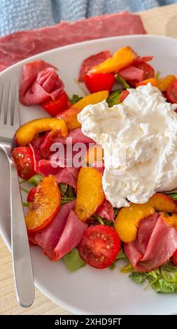 Salat mit gegrilltem Pfirsich, Marmelade, Fetakäse und Rucola. Vertikales Foto Stockfoto