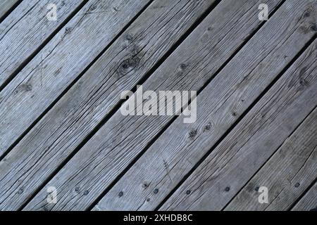 Nahaufnahme der Terrasse im Freien mit verwitterten Terrassenbrettern, die den Test der Zeit bestanden haben. Stockfoto