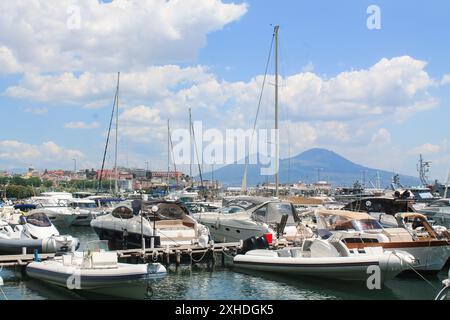 Boote im Yachthafen. Wunderschöne weiße Yachten, die an der Küste auf den Bergen und dem Vesuv-Vulkan geparkt wurden, Neapel, Italien Stockfoto