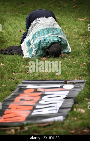 London, England, Großbritannien. Juli 2024. Ein Demonstrant schließt sich dem an. Treffen Sie sich in den Russell Square Gardens und beten Sie einen Moment in der Nähe eines Nachfrageblatts für Jugendliche. Die Nachfrage nach Jugendlichen will Keir Starmers erste Regierungswochen stören. Sie sind entschlossen, klarzustellen, dass die neue Labour-Regierung sie nicht vertritt und dass sie die Mittäterschaft von Labour am Völkermord in Gaza nicht unterstützen. (Kreditbild: © Martin Pope/ZUMA Press Wire) NUR REDAKTIONELLE VERWENDUNG! Nicht für kommerzielle ZWECKE! Stockfoto